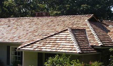 Light browned colored home with brown wood shake and shingles roofing